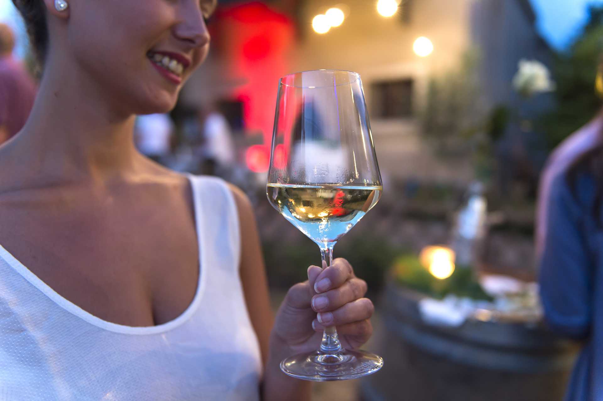 Donna con in mano un bicchiere di vino bianco altoatesino