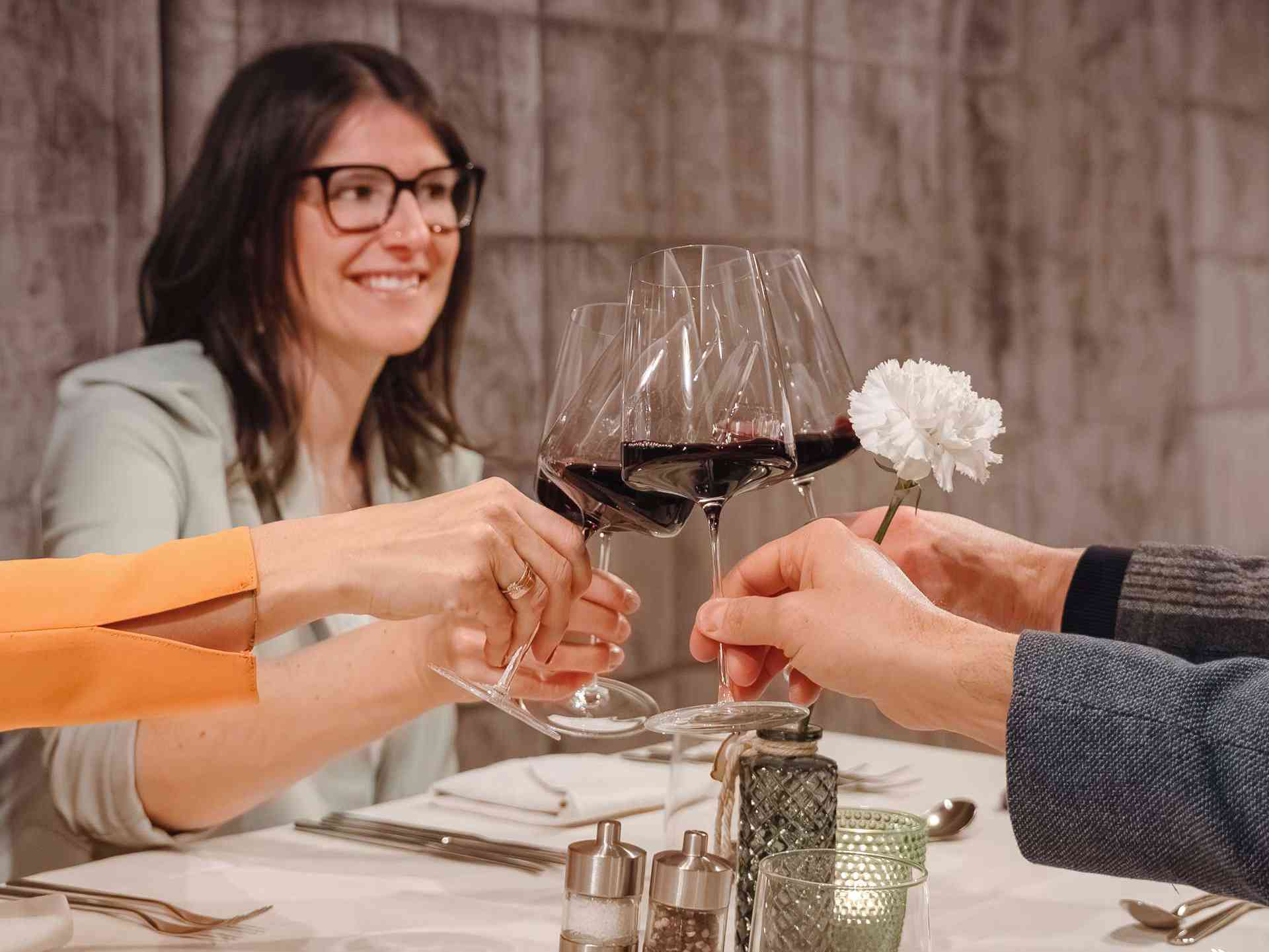 Four wine glasses clink together