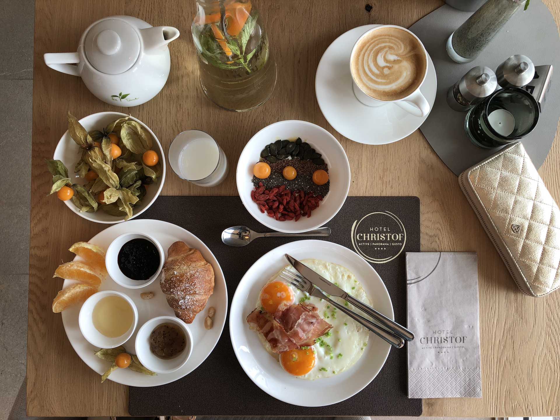 Breakfast table with eggs, croissants, fruit, grains, jam, coffee and tea