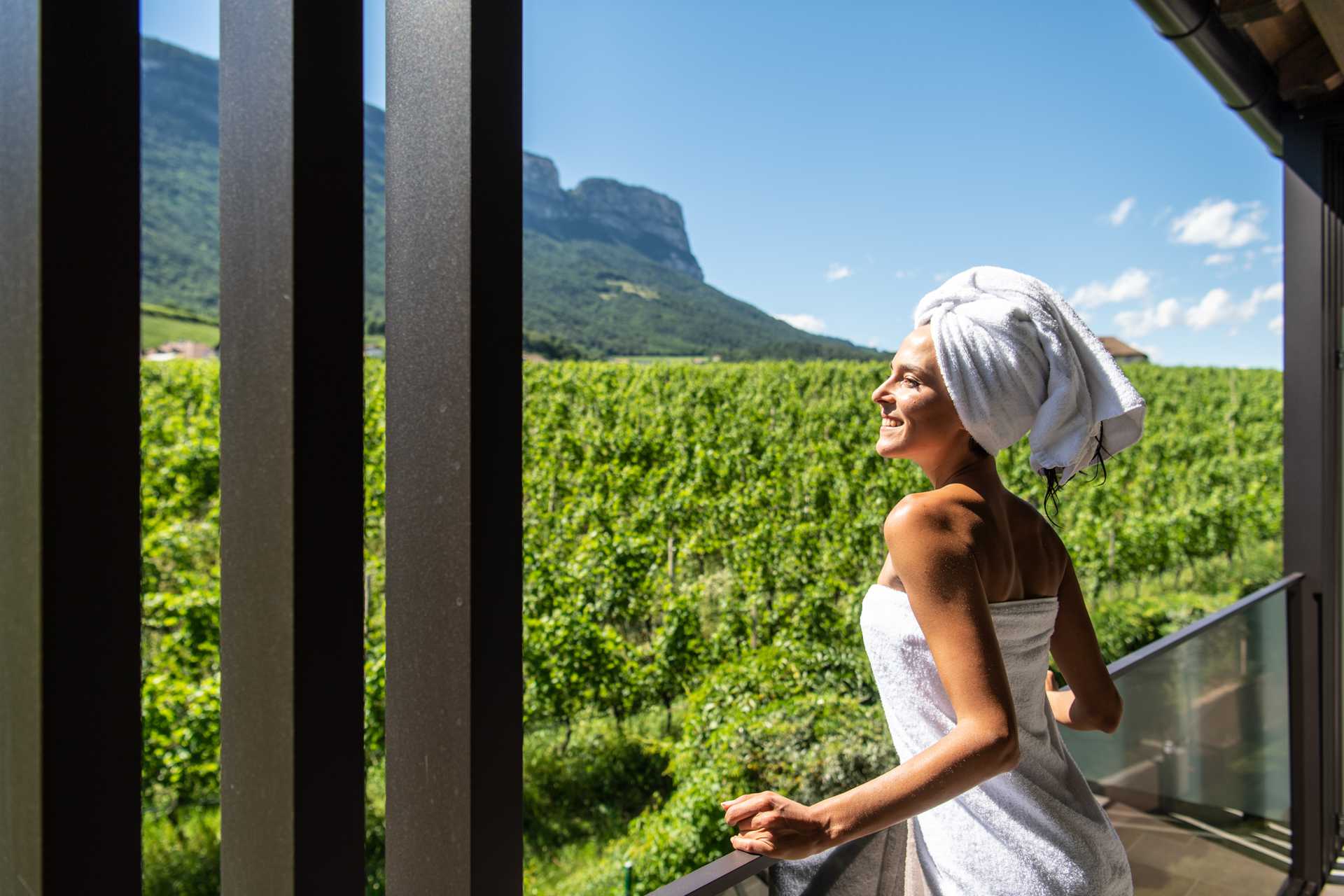 eine Frau schaut über die Weinberge und genießt die Sonne