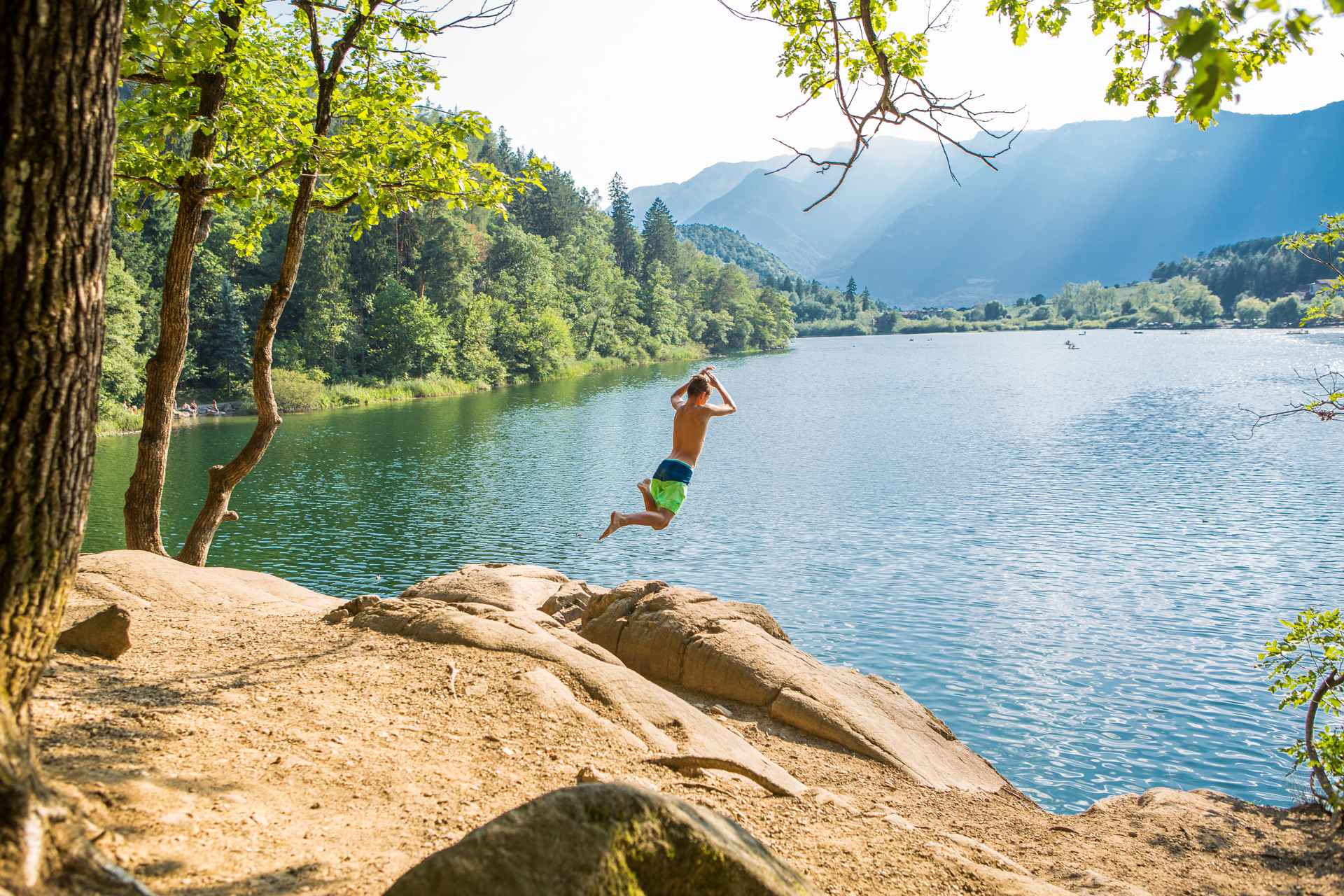 Sprung von einem Felsen in den großen Montiggler See