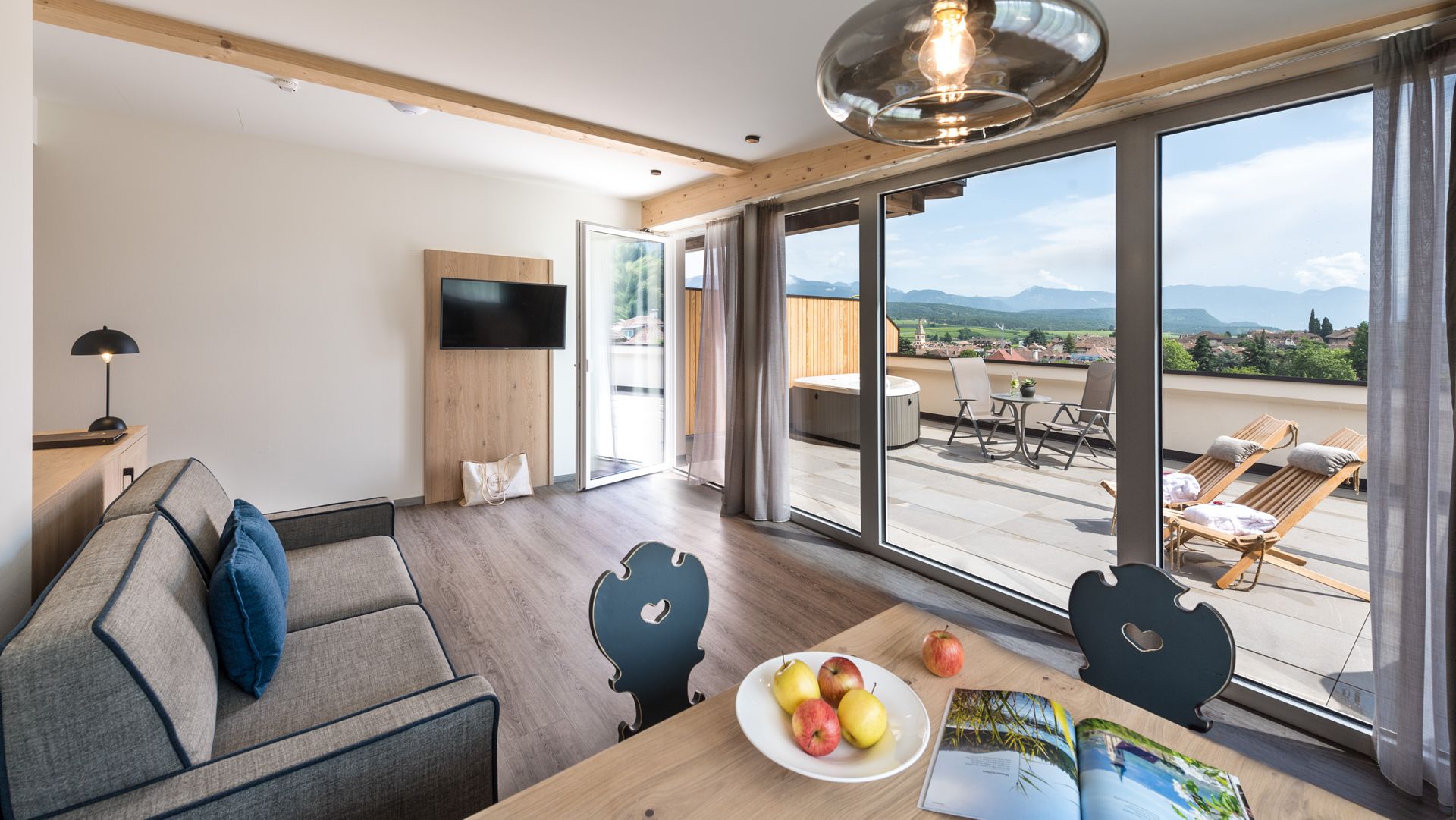 Wohnraum der Penthouse Suite "Graf" mit Aussicht auf die Terrasse mit privatem Whirlpool